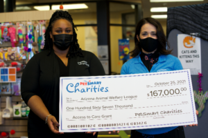 Two women present a large check for $167,000 to the Arizona Animal Welfare League from PetSmart Charities.