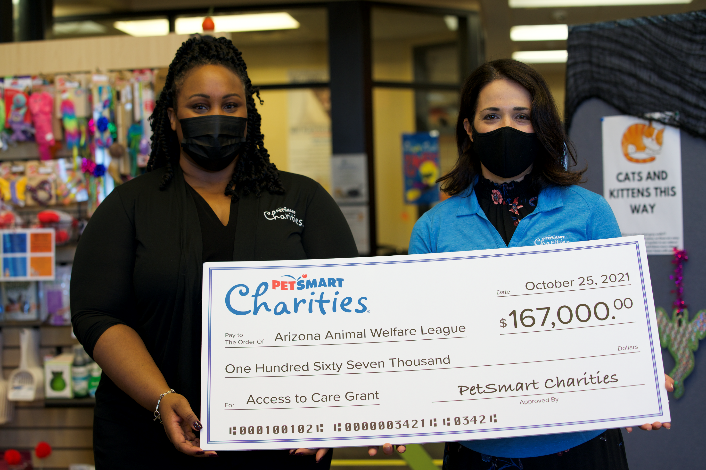 Two women present a large check for $167,000 to the Arizona Animal Welfare League from PetSmart Charities.